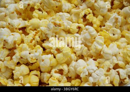 Close-up of freshly popped buttered popcorn. A golden, crispy, and tasty snack ideal for movie nights or food-related content. High-resolution macro Stock Photo
