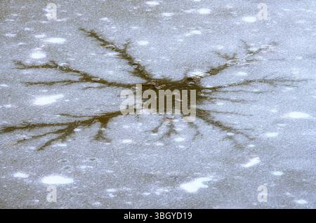 Abstract image of a crack in the ice cover of a muddy lake Stock Photo