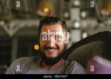 Smiling man relaxing indoors in soft natural light Stock Photo