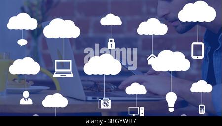 Tapping worker wearing denim shirt using tablet at cafe, with laptop, breakfast items, cloud icons Stock Photo