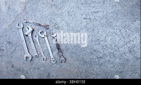 Different wrenches and professional tools lying on a concrete surface, ready for mechanic work Stock Photo