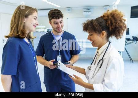 Doctors and nurses collaborating, analyzing medical records and discussing patient treatment in a hospital setting Stock Photo