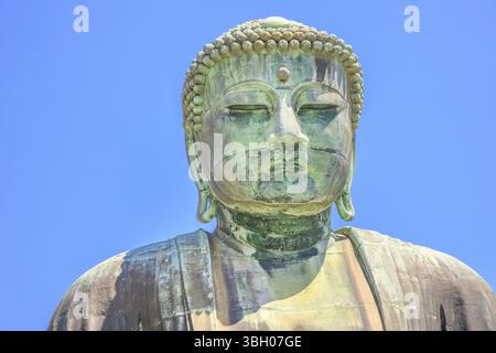 Closeup of Big Buddha or Daibutsu on blue sky, one of the largest bronze statue of Buddha Vairocana. The monumental great buddha in Kotoku-in Temple i Stock Photo