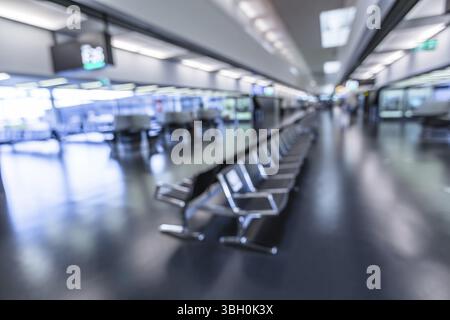 Rows of empty chairs at the waiting area in airport. Terminal area blur effect Stock Photo