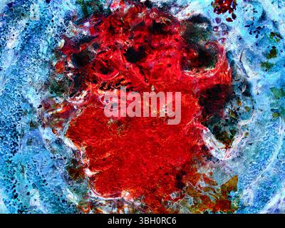 A macro photograph of glass infused with vibrant red and blue pigments, creating an abstract and textured visual reminiscent of crystalline formations Stock Photo