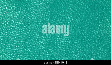 A close up full frame view of a vibrant teal colored leather texture, showcasing its natural grain Stock Photo