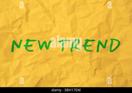 New Trend. Words on crumpled yellow sheet of paper Stock Photo