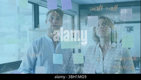 Image of data processing against caucasian male and female colleagues discussing at office Stock Photo