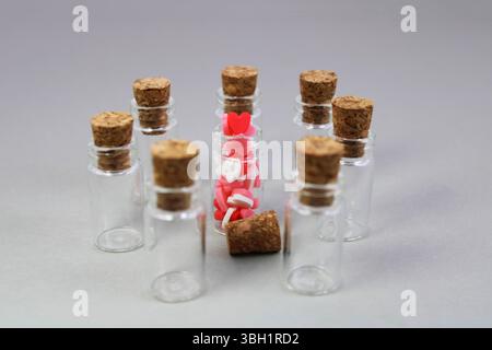 Glass bottle with hearts surrounded by other empty bottles Stock Photo