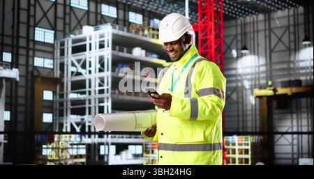 American Engineer Constructing Rocket Center With Smartphone And Blueprint In Hand Stock Photo