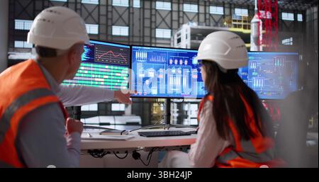 Young Engineer Operates Computer Program At Moon Exploration Agency Factory. Stock Photo