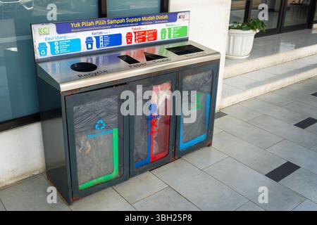 Jakarta, Indonesia - February 9, 2025: Trash can with three different colored bins for recycling. The bins are labeled with the different types of rec Stock Photo