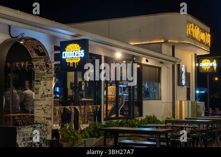 Jakarta, Indonesia - February 9, 2025: Restaurant with a neon sign that says Lawless. There are tables and chairs outside and inside Stock Photo