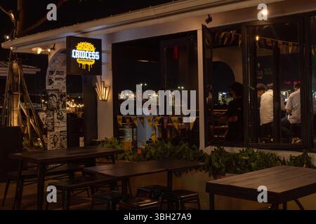 Jakarta, Indonesia - February 9, 2025: Restaurant with a neon sign that says Lawless. There are tables and chairs outside and inside Stock Photo