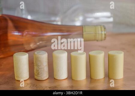 Synthetic wine corks on the background of a corked bottle of rose wine. Stock Photo
