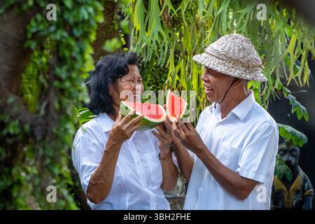 Elderly couple sharing a joyful moment with watermelon, showing love, laughter, and the warmth of lifelong companionship Stock Photo