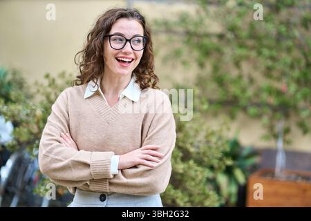 Young happy smiling professional business woman standing outdoor looking away. Stock Photo