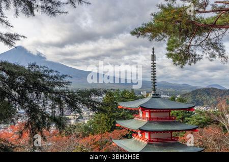 Chureito Pagoda framed by pine branches with Mount Fuji in the distance under dramatic clouds overlooking Fujiyoshida Stock Photo