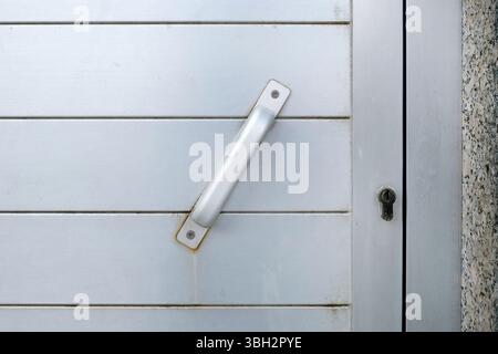 Locked metal door with a metal handle Stock Photo