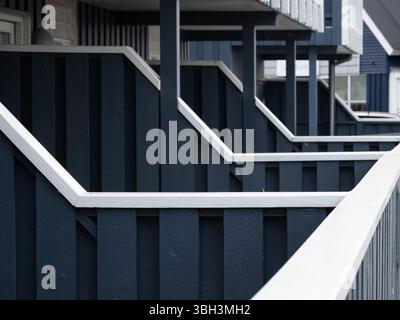 Row of blue wooden fences with white top separating condo units from each other Stock Photo