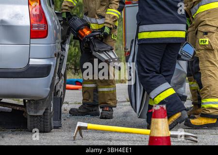 Firefighters and rescuers cut open a car body during a rescue operation ...