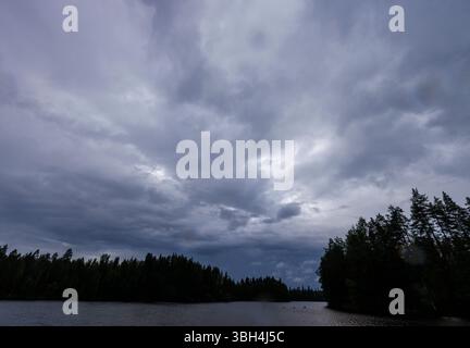 Gray rain clouds over Finnish forest lake at Summer, Finland Stock Photo