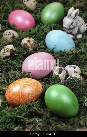 Easter colored eggs scattered on a green moss as an element of a holiday decoration ideas Stock Photo