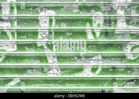 Green metal shutter with peeling paint. Ideal use for background / wallpaper Stock Photo