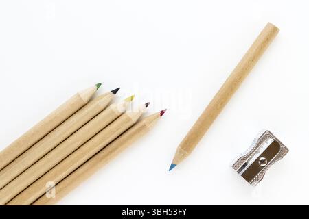 Group of crayons and pencil sharpener on white background and seen from above Stock Photo