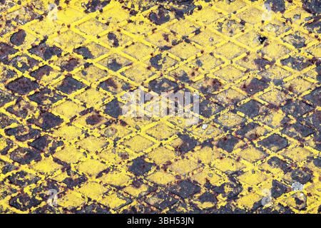 Corroded metal background. Rusted yellow painted metal plate. The metal surface rusted spots. Rystycorrosion Stock Photo