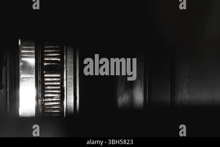Old window with dirty light view. Sunlight entering through the window of an old house creating a creepy ambience Stock Photo