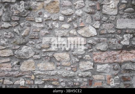 Background of old natural stone wall. Ideal for backgrounds and textures Stock Photo