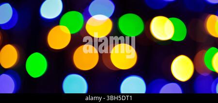 Multicolored Bokeh Background with Blurred Yellow Green Blue Orange Circles on Dark Background Stock Photo