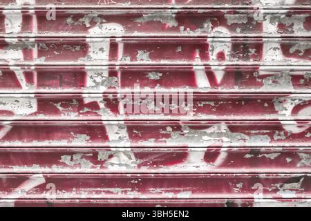 Red metal shutter with peeling paint. Ideal use for background / wallpaper Stock Photo