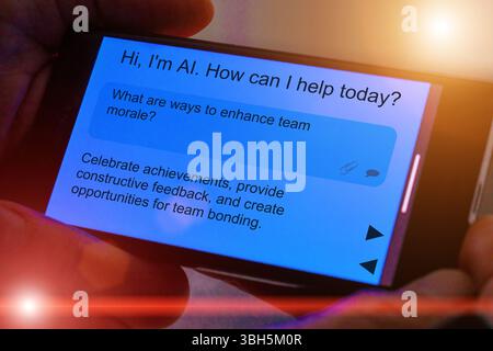 Question for artificial intelligence on smartphone screen. What are ways to enhance team morale? Stock Photo