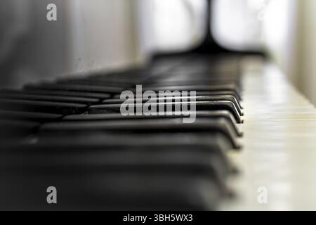 Old Piano keyboard with selective focus, behind a blurred background Stock Photo