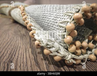 Small roller wicker mat on vintage table. Furnishing accessory for home. Close-up Stock Photo