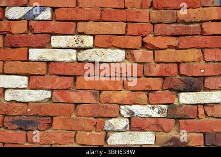 Fragment of a wall of red brick with a few bricks of white refractory silica brick Stock Photo