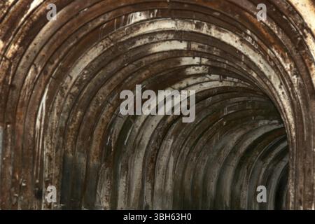 An old tunnel with an arched metal beams in mauntain Stock Photo