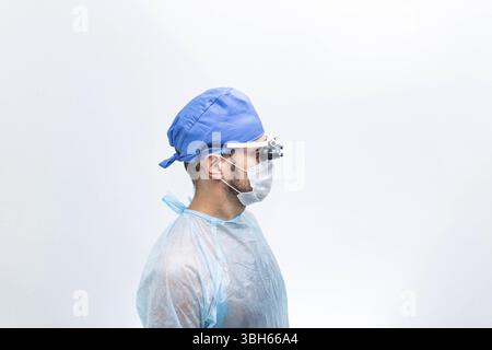 Side profile of a medical professional wearing a mask and blue cap Stock Photo