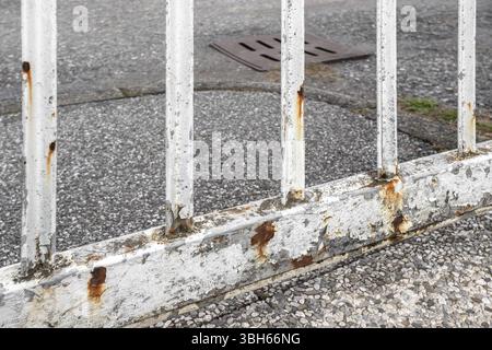 Rusty white gate on gray street background Stock Photo
