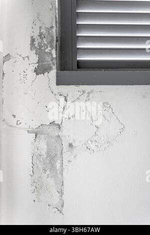 Peeling painted wall, texture, grunge background, cracked paint with white wall with window Stock Photo