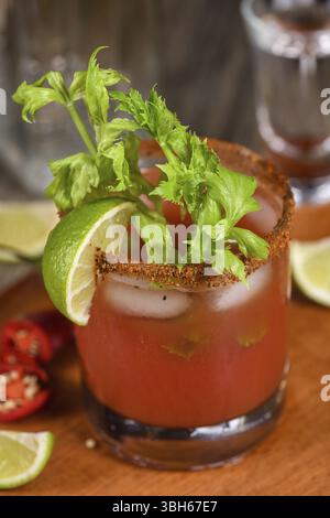 Michelada the Mexican Bloody Mary. Made with tequila, spicy sauce, served over ice in a glass of celery with a peppery rim, garnished with a stalk of Stock Photo