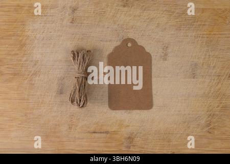 Tag with Twine Roll on Wooden Surface. Rustic Minimal Label Concept. Stock Photo