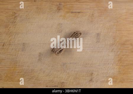 Twine Roll on Rustic Scratched Wooden Table Stock Photo