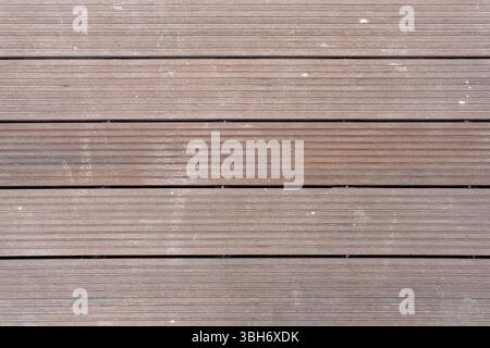 Wooden board with a grainy texture. The board is brown and has a rough surface. The image has a rustic feel to it Stock Photo