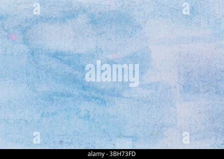 Macro close-up of hand painted light blue watercolor background with watercolour stains and brush strokes. Textured paper background with copy space. Stock Photo