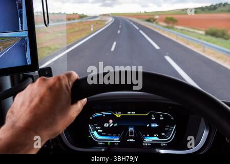 Truck dashboard screen while driving on a highway, showing speed and engine RPM data focused on fuel efficient driving. Stock Photo