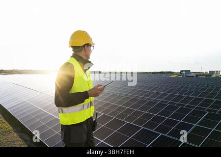 Engineer with tablet computer on a solar energy power station. Stock Photo
