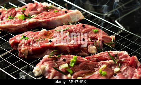 Veal steak on grill rack, dark background. Stock Photo